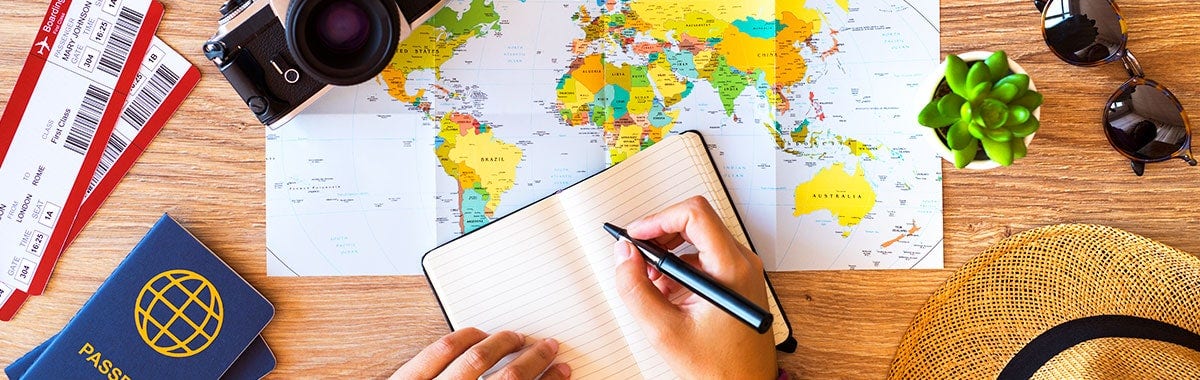 somenone writing down notes overtop a map with a passport to the side