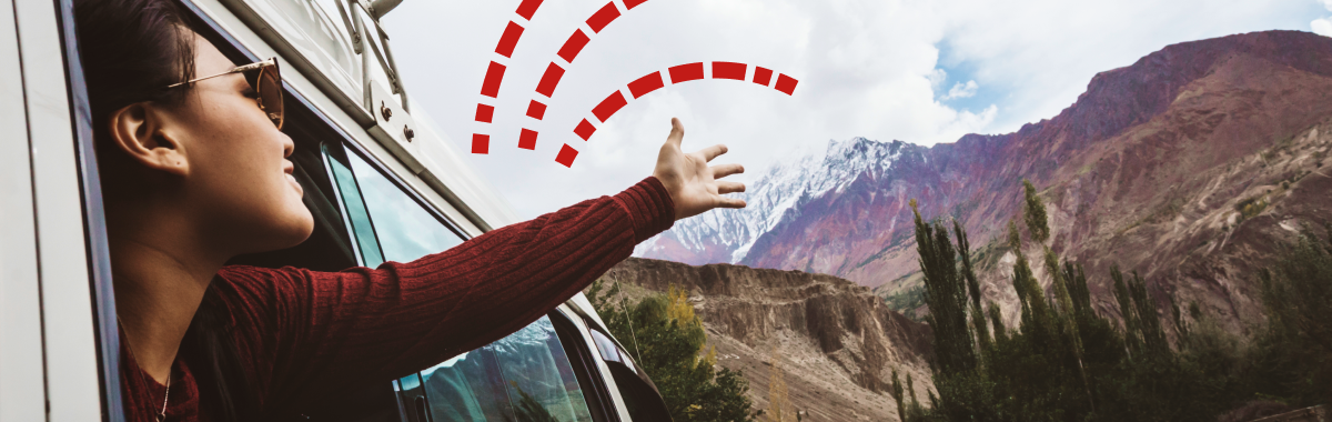 woman embracing the outdoors by putting her arm out the car window
