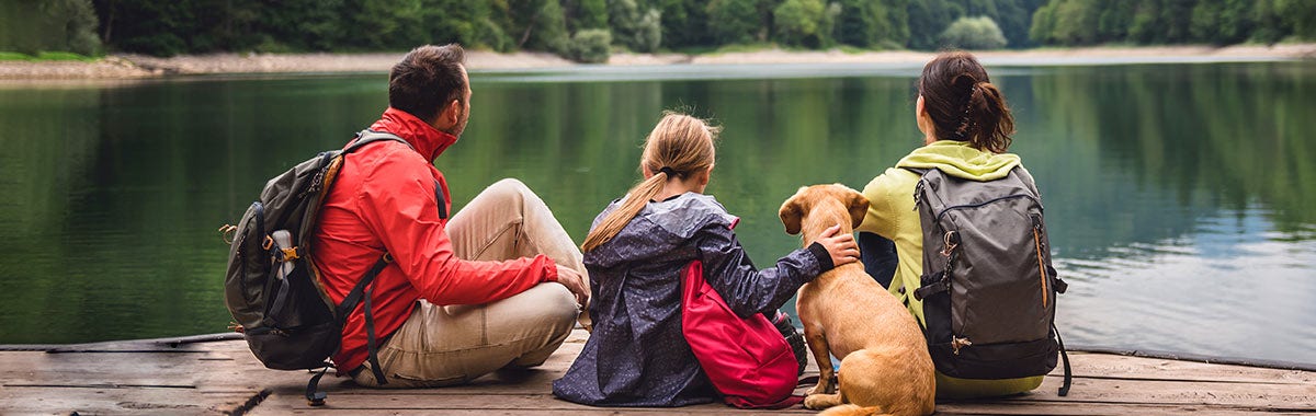 family sitting at the end of a dock 
