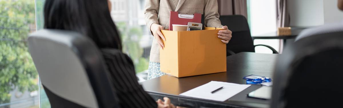 person packing up their belongings at work