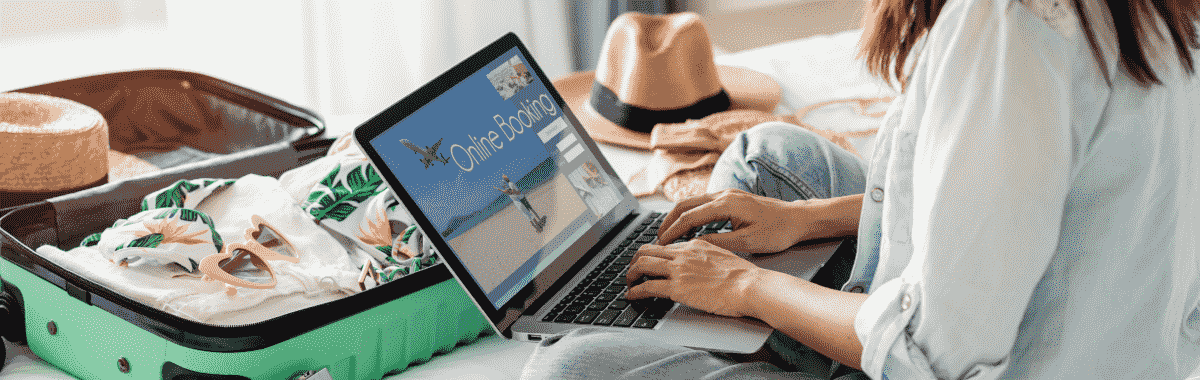 woman on a kayak with her arms out stretched over a emerald green lake
