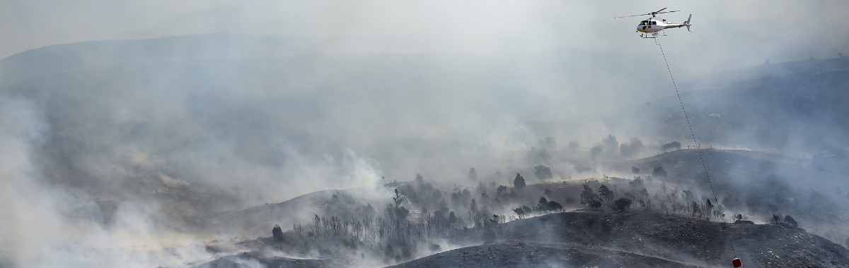 helicopter above smoldering forest