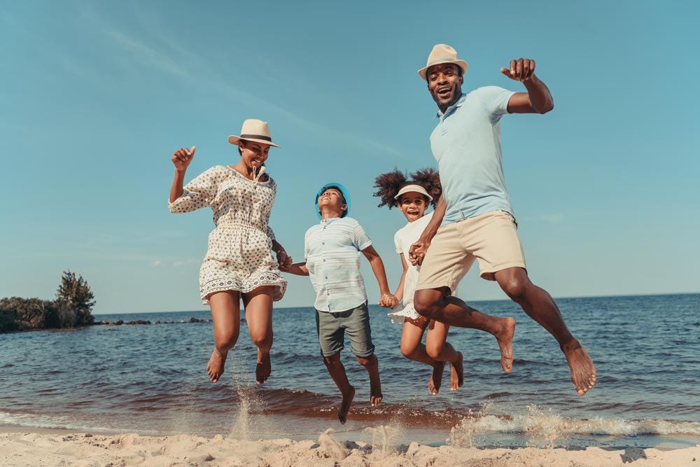 family jumping at the beach
