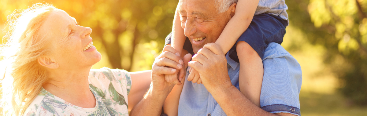 grandparents with child on their shoulders