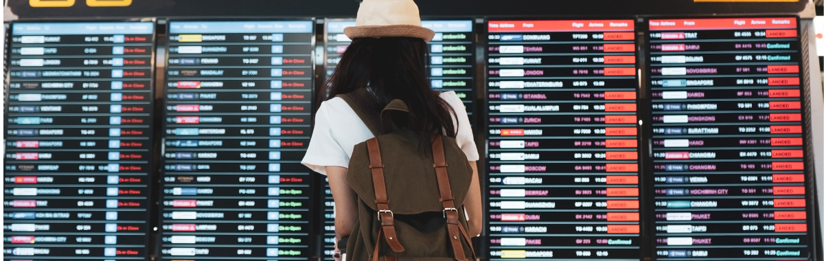 woman in an airport looking at flight status board