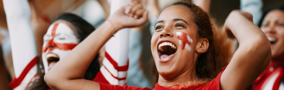 woman on a kayak with her arms out stretched over a emerald green lake