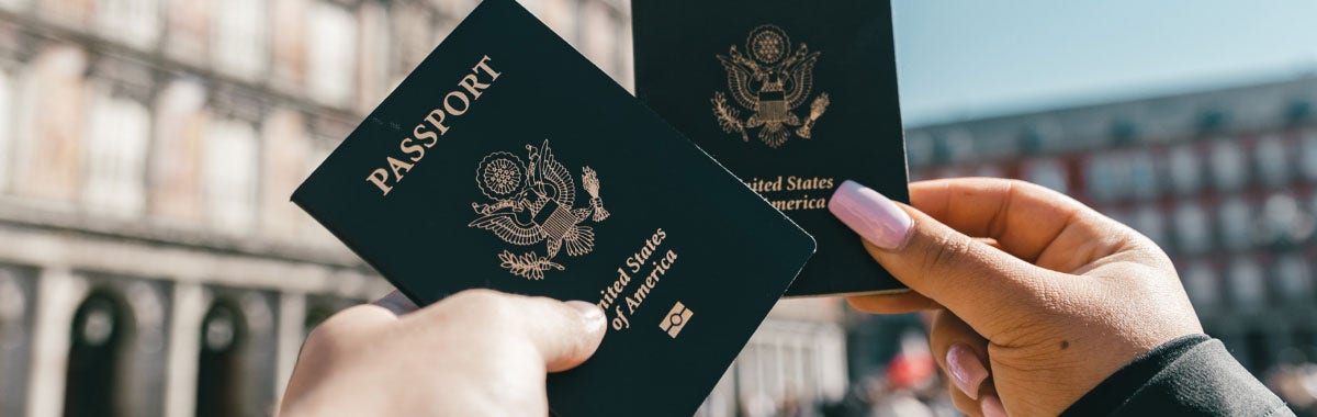 two people holding up their passports in front of the roman colosseum 