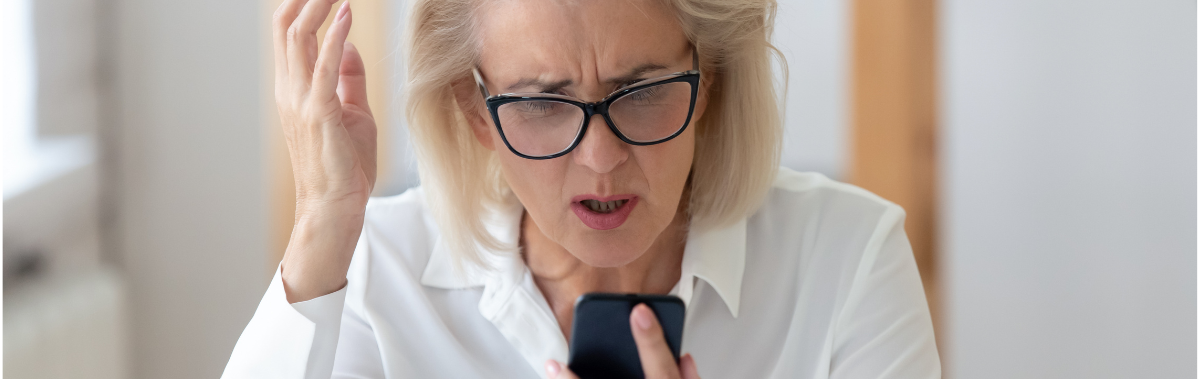 woman looking at her phone frustrated