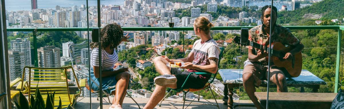 people sitting on a balcony with one of them playing a guitar