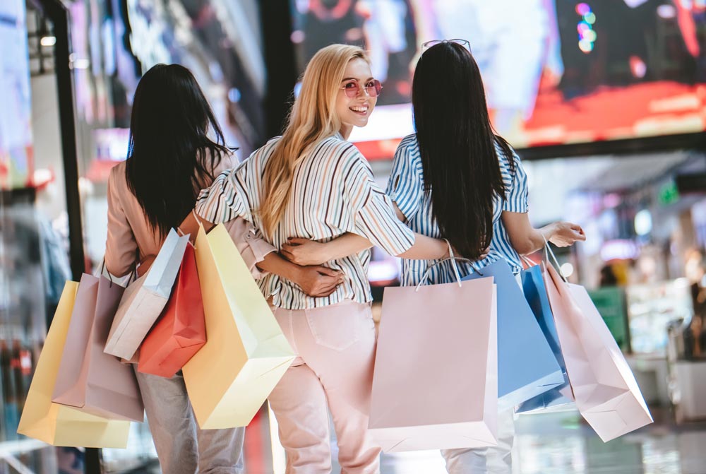 3 women shopping with the one in the middle looking back at the viewer