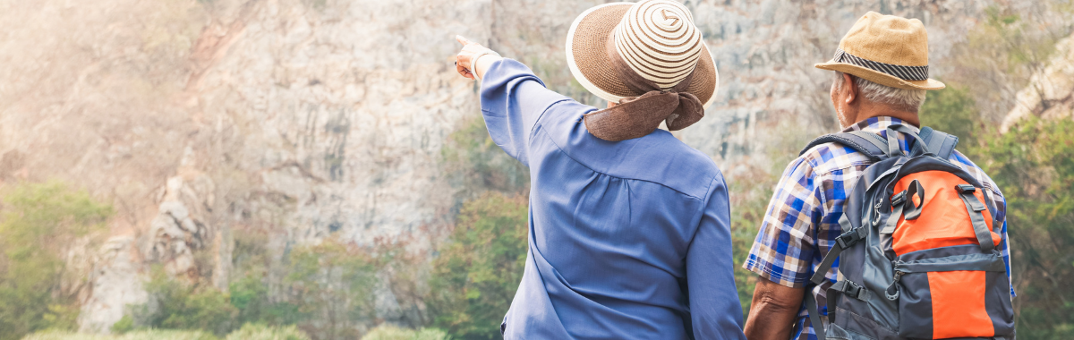Senior couple hiking and pointing at something