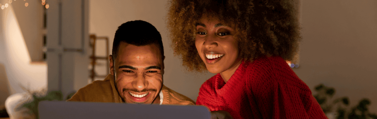 couple at the computer happy to buy travel insurance