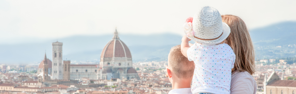 family with kid being held looking at european building