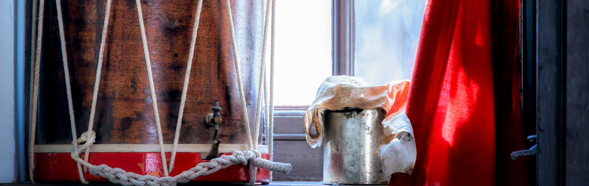 revolutionary drum, coat, and cup sitting in a window
