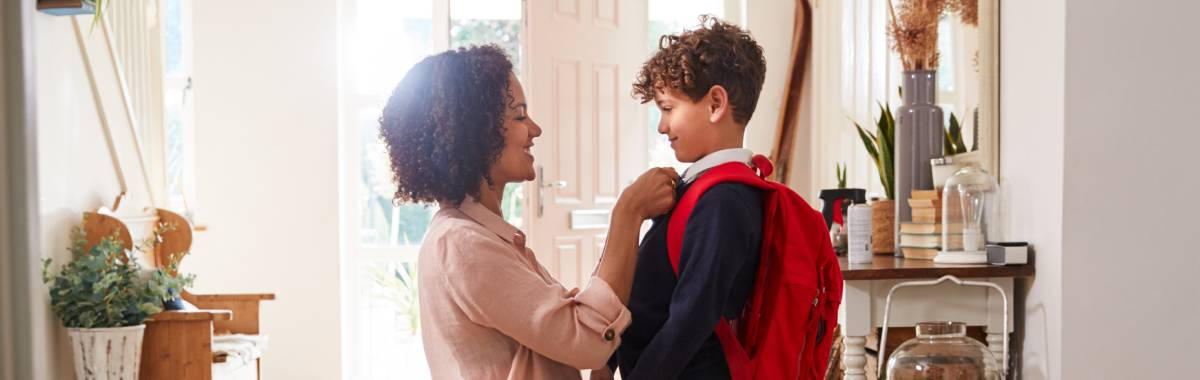 mother helping her son get ready for school