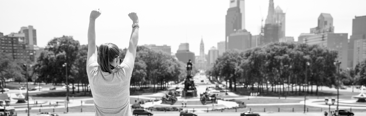 Woman doing the rocky pose at the top of the steps in Philly