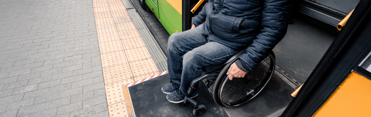 wheelchair traveler getting off a bus with a lift
