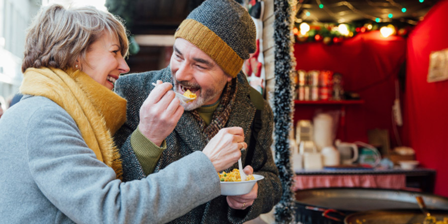 couple eating street food during the holidays