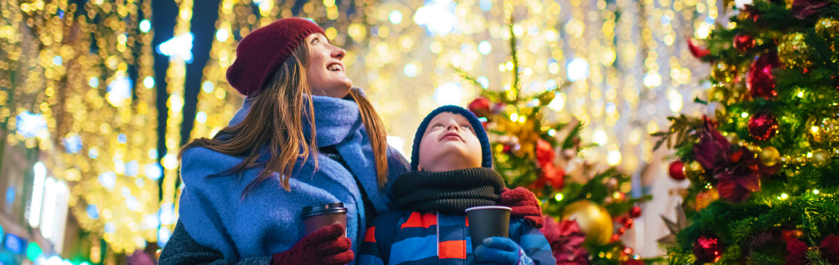 mother and son in awe of christmas lights around them
