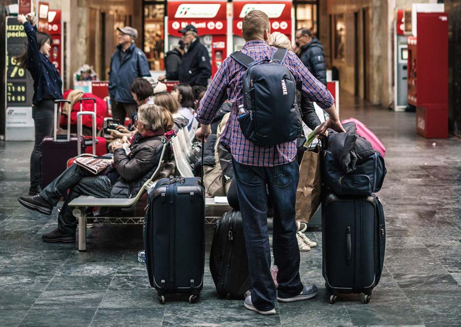 man holding a lot of luggage at the airport