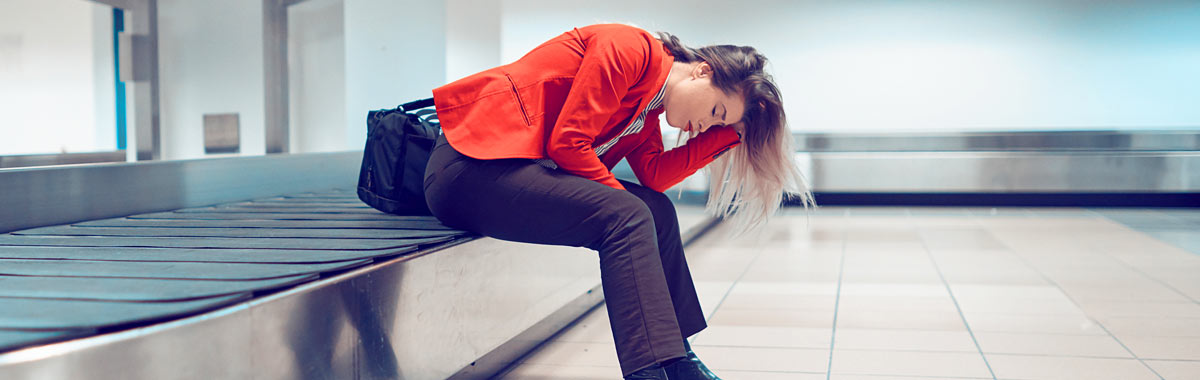 woman in airport with lost luggage