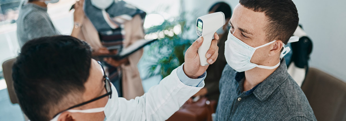 doctor using thermometer to check for COVID sickness