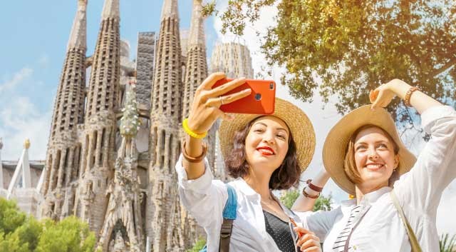 two people taking a photo in front of Sagrada Familia in Barcelona