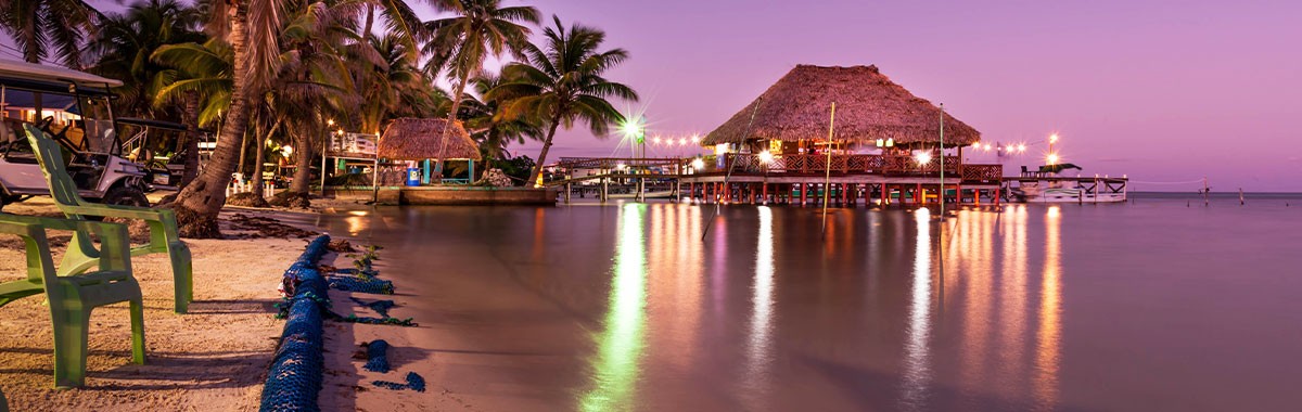Belize beach at night with lights on the water