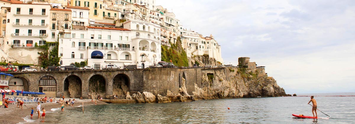 people on the beach and colorful coastal architecture in Amalfi, Italy