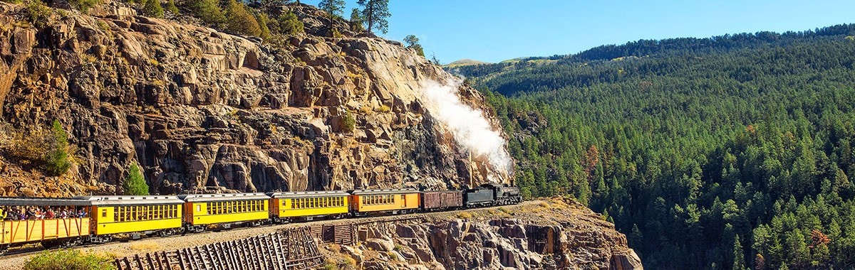 steam engine train travels through mountains in Colorado