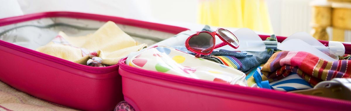 woman packing for a cruise with open suitcase