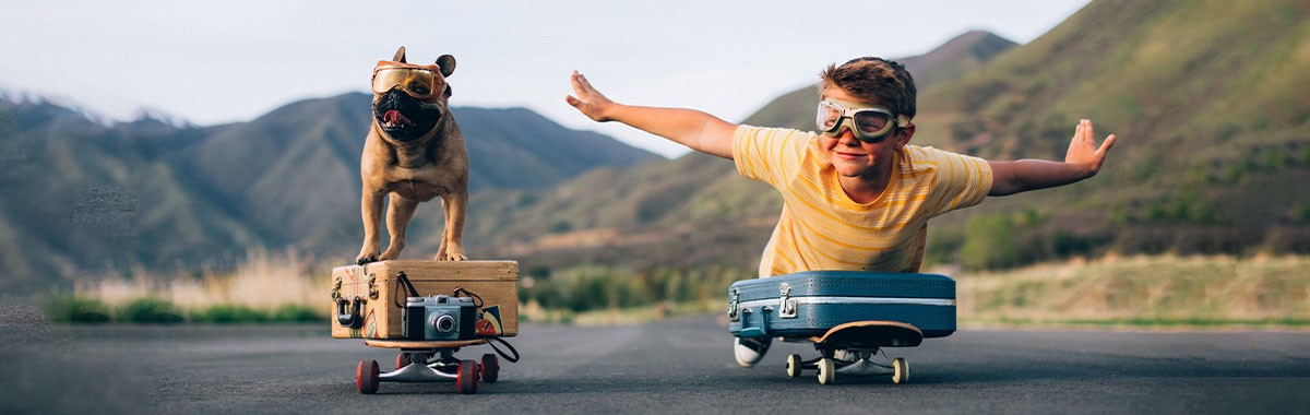 kid skateboarding with a dog and luggage