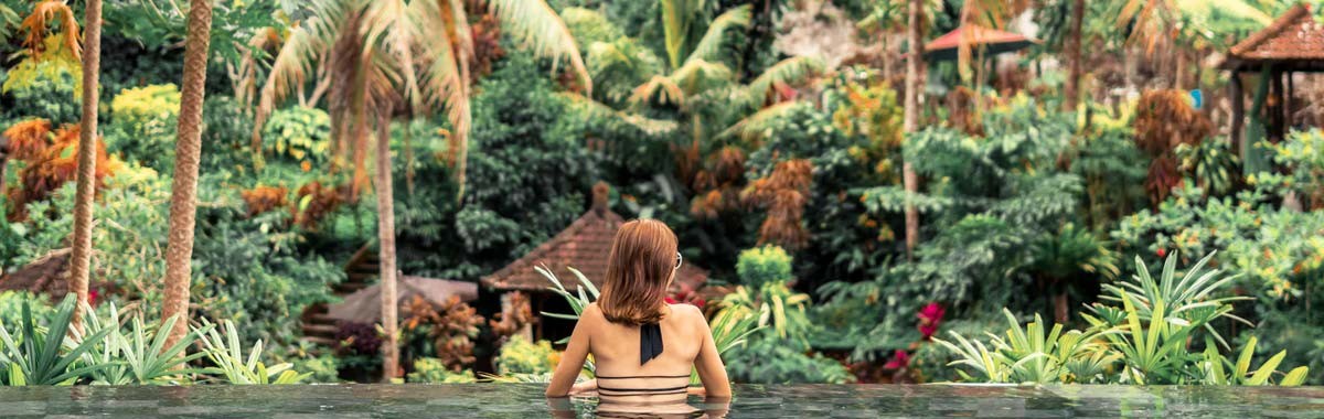 woman in infinity pool looking at jungle in Bali