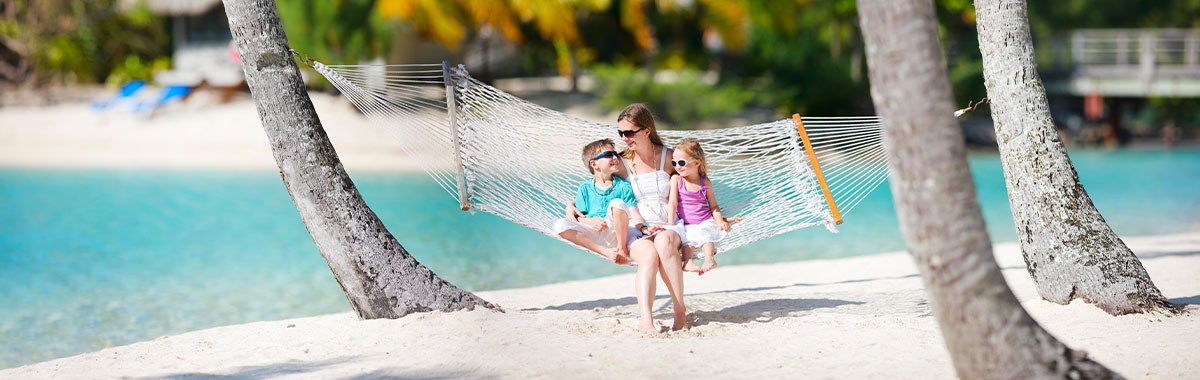mother and kids in a hammock on a beach vacation