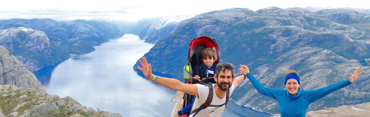 family hiking in Norway with fjord behind them