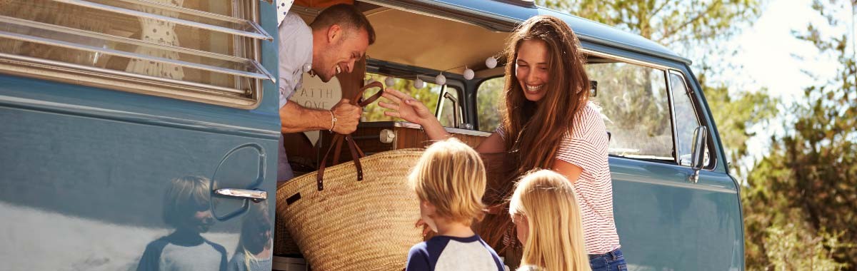 Family in blue camper van on a road trip vacation