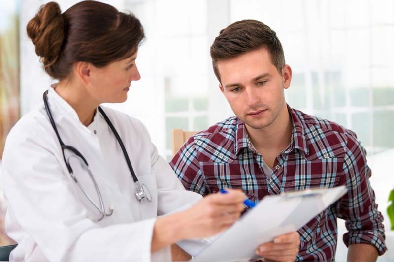 man talking with doctor holding papers