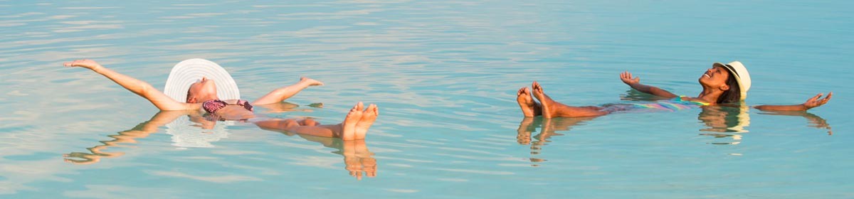 two women float in the Dead Sea on vacation