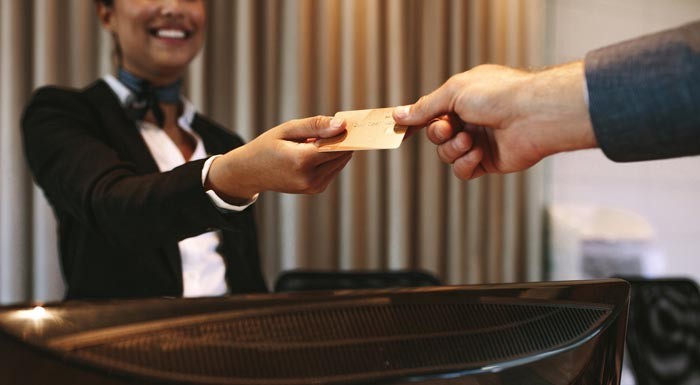 man handing credit card to hotel concierge