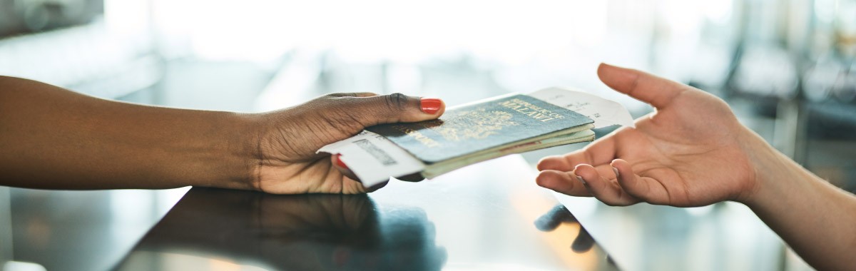 person handing passport and visa back to traveler